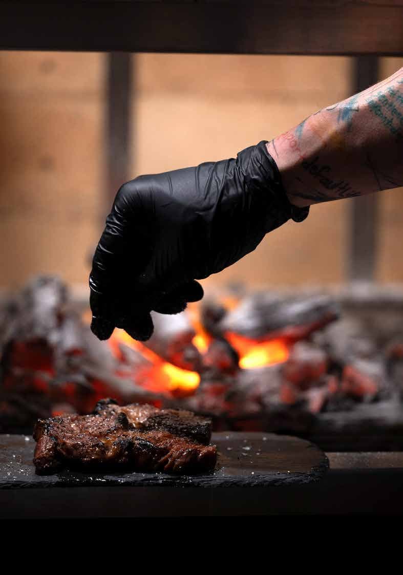 A steak being finished over Earle’s charcoal grill