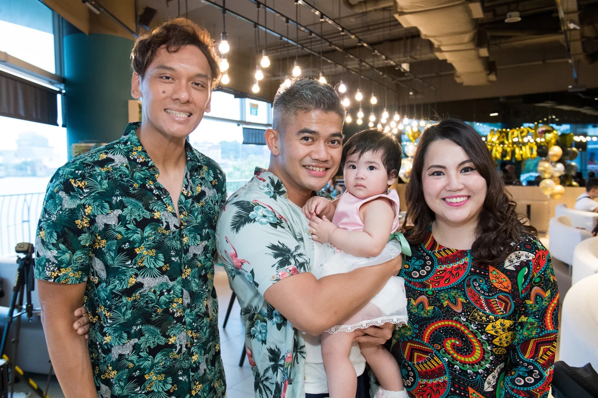 Three guests and a young child posing together at an Earle birthday celebration